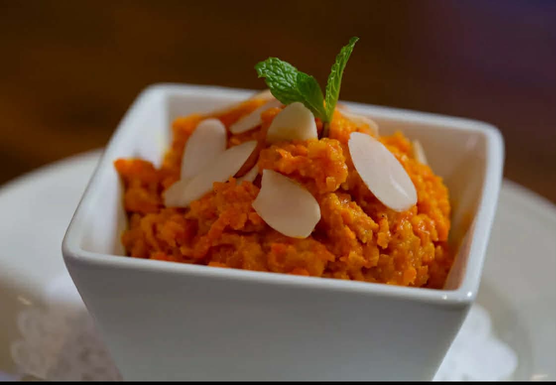 A sweet and dense dessert made from carrot, semolina, ghee, and sugar, flavored with cardamom and nuts.