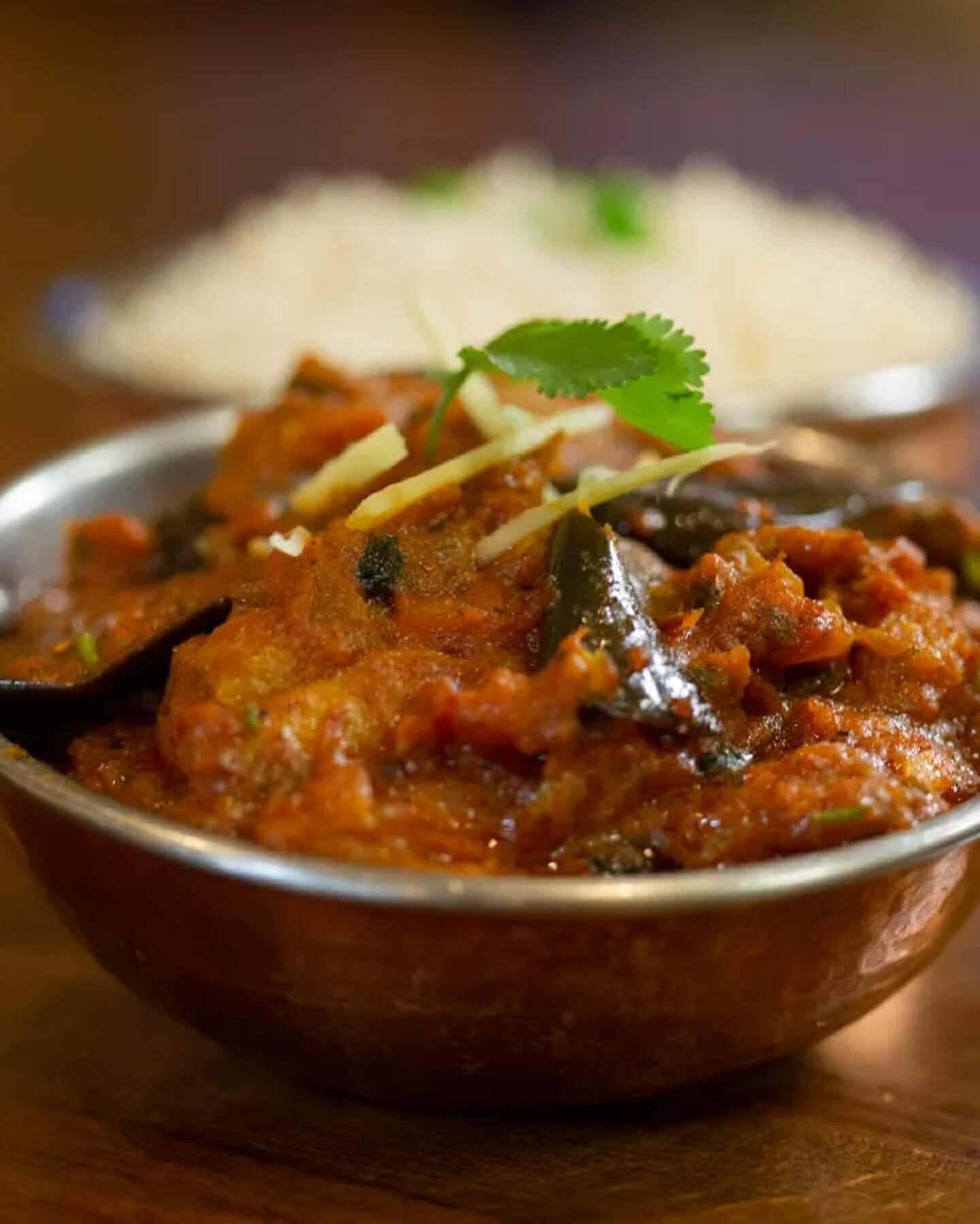 Aromatic chicken curry cooked with roasted eggplant and spices, served with rice.